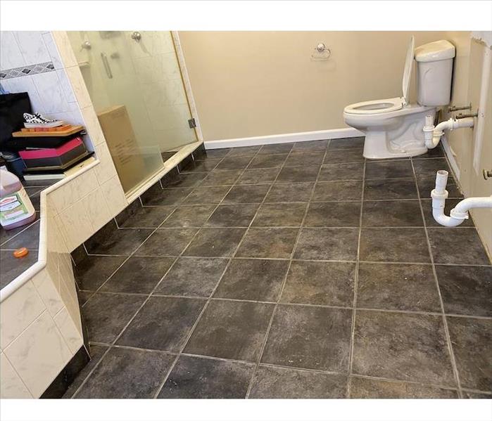 Bathroom with tile floor with pipes exposed